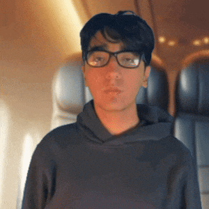a man wearing glasses and a hoodie looks at the camera