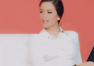 a woman in a white shirt is sitting on a couch with a tablet