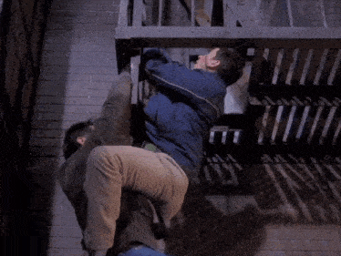 a man is carrying another man up a set of fire escapes