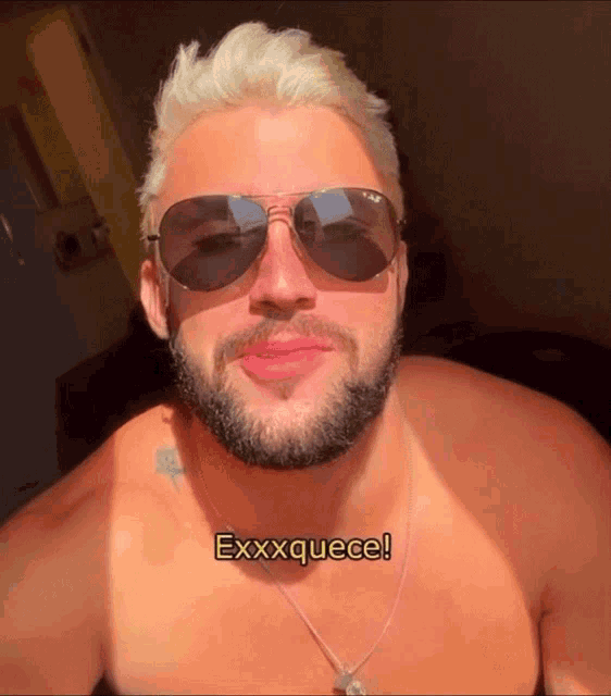 a shirtless man wearing sunglasses and a necklace with the words exxxxquece on his chest