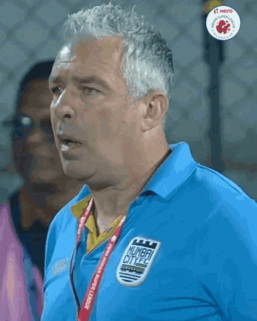 a man wearing a blue shirt with the word mumbai city on it
