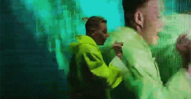 a man in a neon yellow jacket is standing next to another man