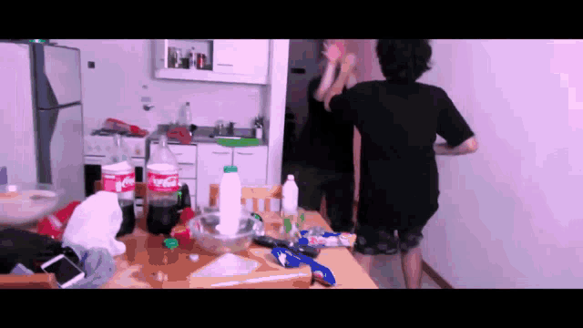 a bottle of coca cola sits on a messy kitchen table