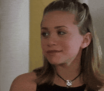 a close up of a woman wearing a black tank top and a necklace