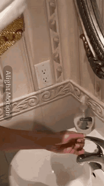 a person is washing their hands in a bathroom sink with a light motion app on the screen