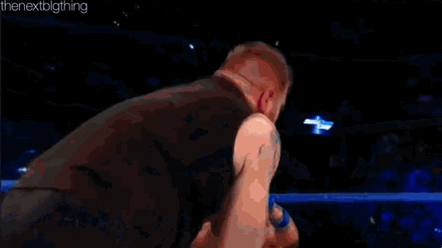 a man is wrestling another man in a ring .