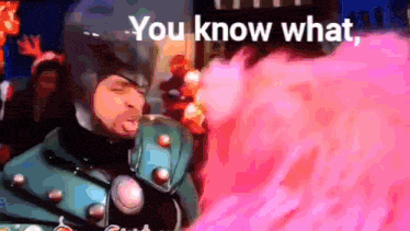 a man in a superhero costume is blowing pink smoke and says you know what