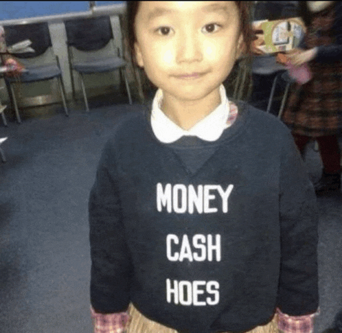 a little girl wearing a black sweater that says money cash hoes
