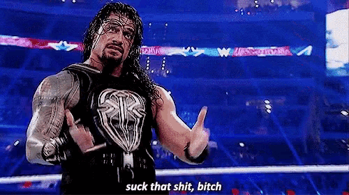 roman reigns is standing in a wrestling ring making a funny face .