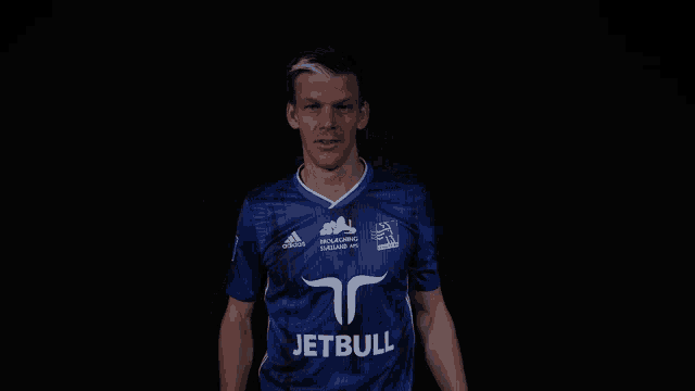 a man wearing a blue adidas shirt with the word jetbull on it