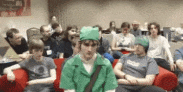 a group of people are sitting on a couch and one of them is wearing a shirt that says zero