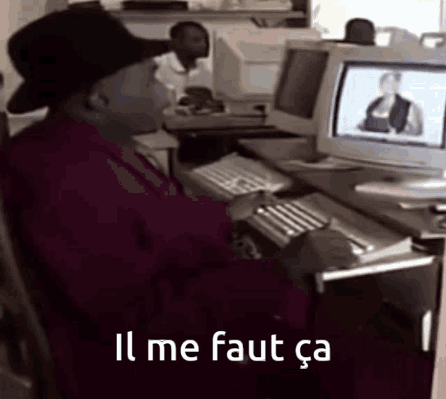 a man is typing on a keyboard with the words il me faut ca written below him
