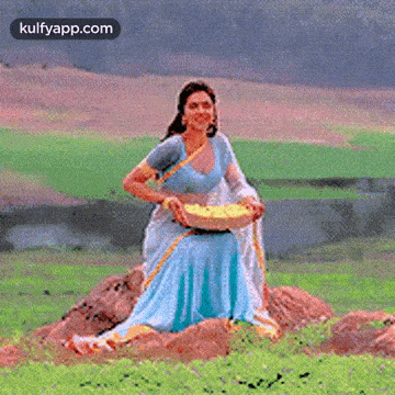 a woman in a blue dress is standing in a field holding a basket of flowers .