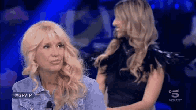 two blonde women are sitting next to each other on a television show called gfvip .