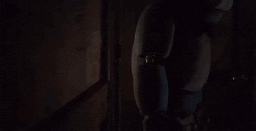 bonnie from five nights at freddy 's is standing in the dark with glowing eyes .
