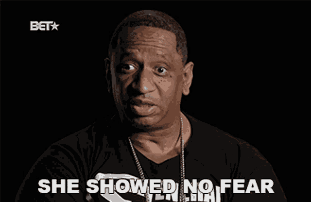 a man in a black shirt says she showed no fear in white letters