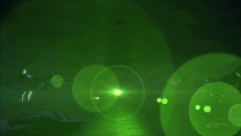 a green light is shining on a dark surface