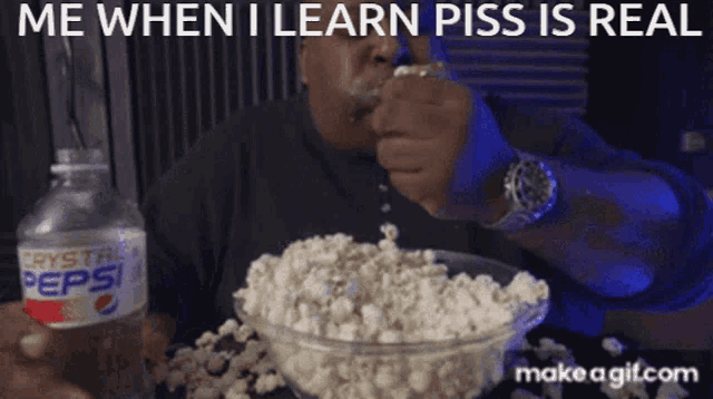 a man is eating popcorn with a bottle of pepsi in the background