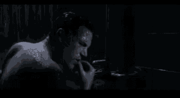 a man is taking a bath in a dark room and screaming .