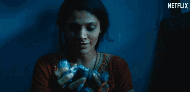 a woman in a dark room with a netflix logo on the bottom
