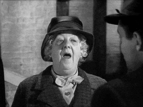 a woman wearing a hat is talking to another man