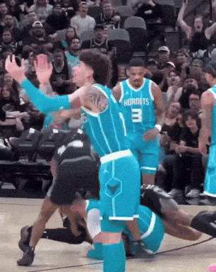 a hornets player with the number 3 on his jersey is playing basketball