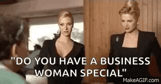two women are standing next to each other in a room talking to each other .