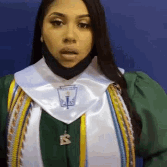 a woman in a graduation cap and gown with the letter s on her neck