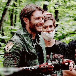 a group of men are standing next to each other in a forest .