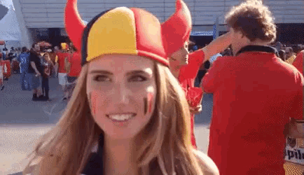 a woman wearing a red , yellow and black hat with horns .