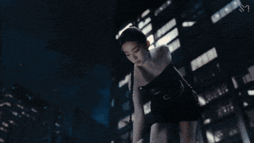 a woman in a black dress is laying on the floor and looking at her reflection