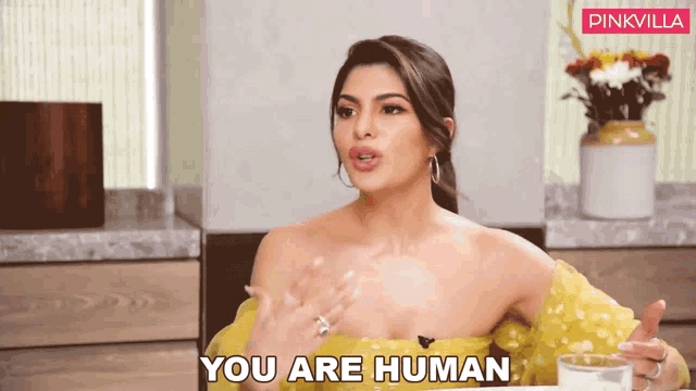 a woman in a yellow dress is talking and says you are human