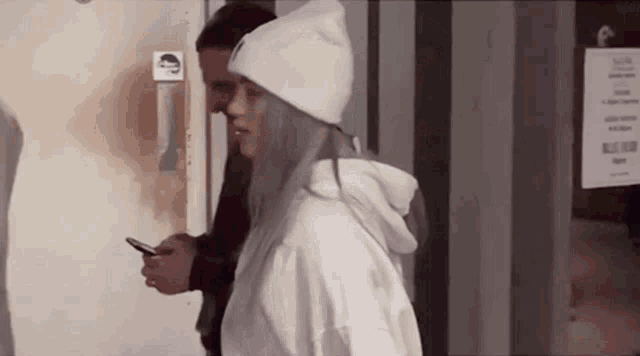 a woman wearing a white beanie and a white hoodie