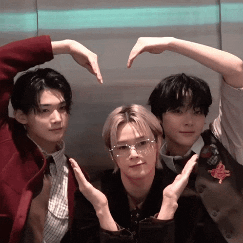 three young men are making a heart with their hands