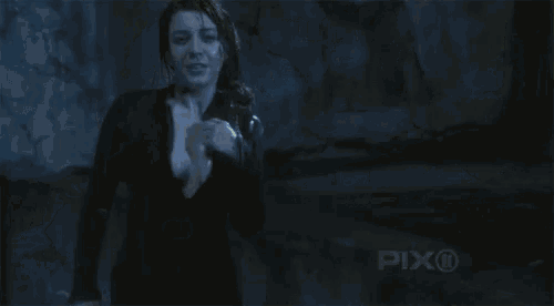 a woman is taking off her top in the dark
