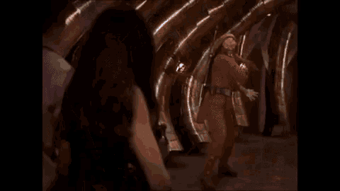 a woman is standing next to a man in a space suit in a spaceship .