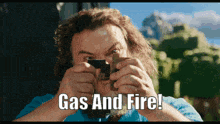 a man taking a picture with the words gas and fire