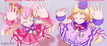 two anime girls are standing next to each other and waving at the camera .