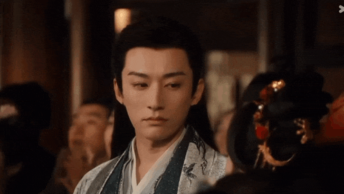 a man in a kimono looks at a woman in a crowd