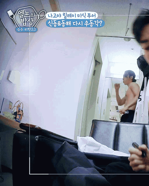 a man without a shirt is sitting in front of a mirror in a room with korean writing on it