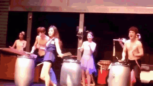 a group of people are dancing and playing drums