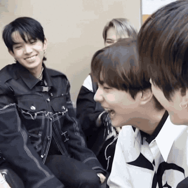 a group of young men are sitting next to each other and laughing together .