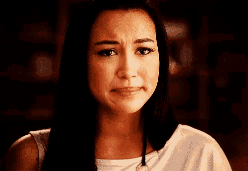 a woman is making a sad face with her eyes closed .