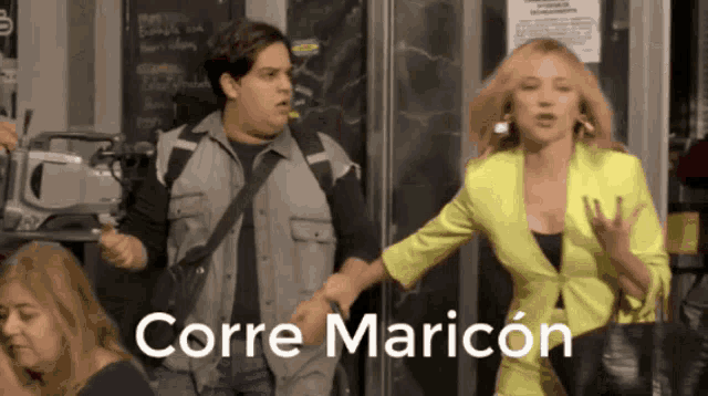 a woman in a yellow jacket is being held by a man in a gray vest and the words corre maricon are on the bottom