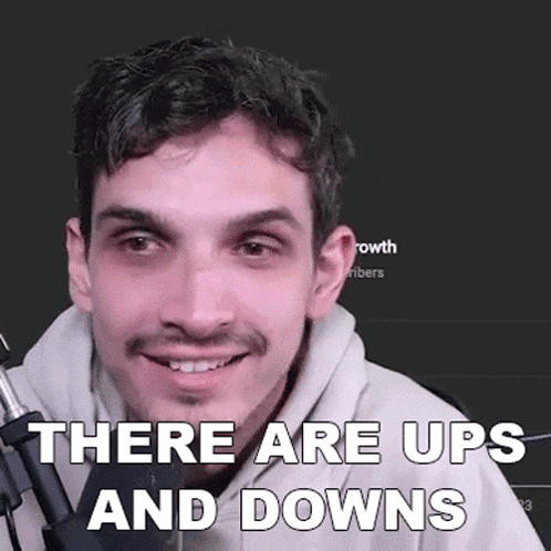 a man with a beard is smiling while holding a microphone and says there are ups and downs .