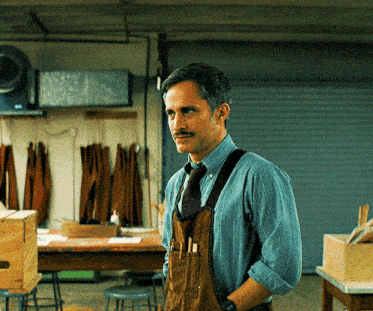 a man with a mustache is wearing suspenders