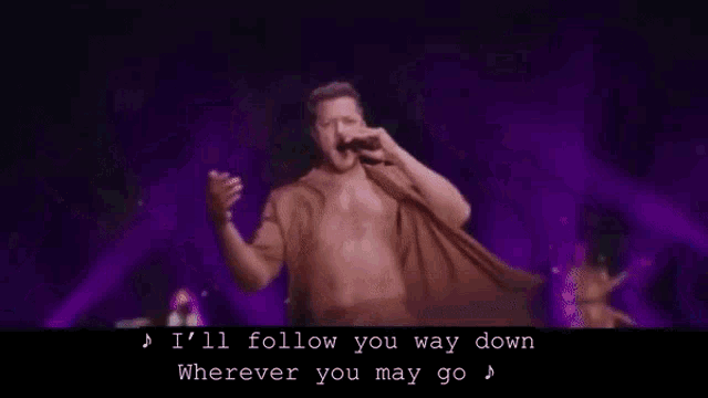 a shirtless man singing into a microphone with the words " i 'll follow you way down wherever you may go "