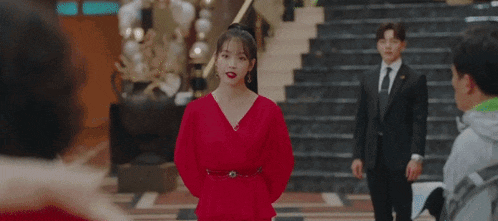 a woman in a red dress is holding a knife and a piece of paper .