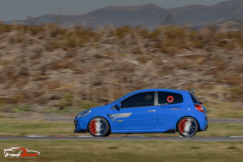 a blue car with the letters g on the side