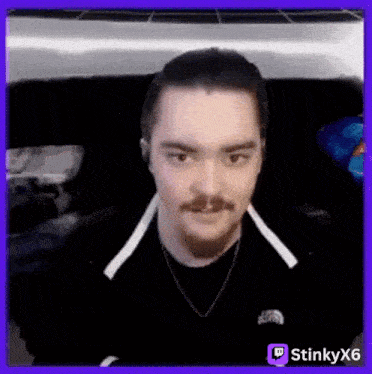 a man with a beard and mustache is wearing headphones and a necklace .